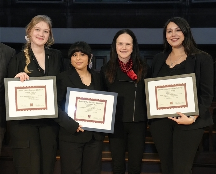 Three students holding awards with college president