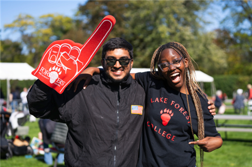 Two Foresters posting with a novelty foam hand
