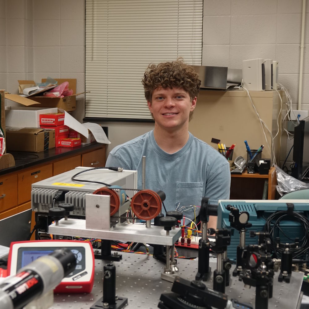 Clayton Berg in a physics lab with lab equipment