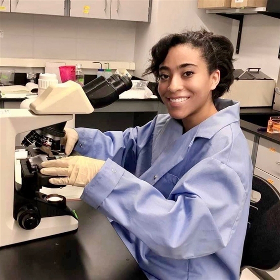 Student at microscope in lab coat