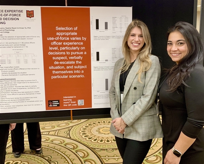 Two students in front of psychology research poster