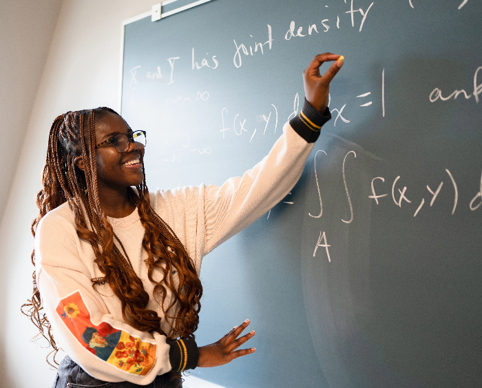 student working on a blackboard