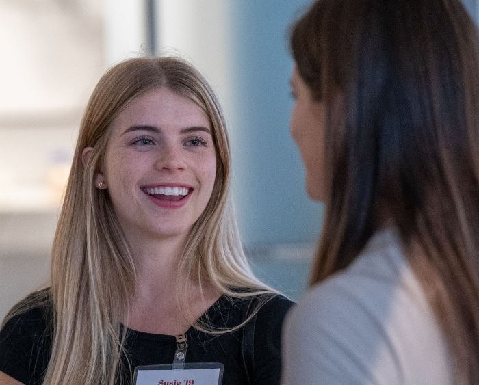 blonde student chatting with another student