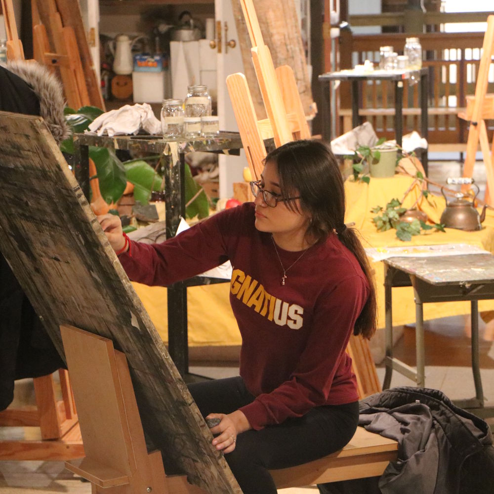 a student painting at an easel