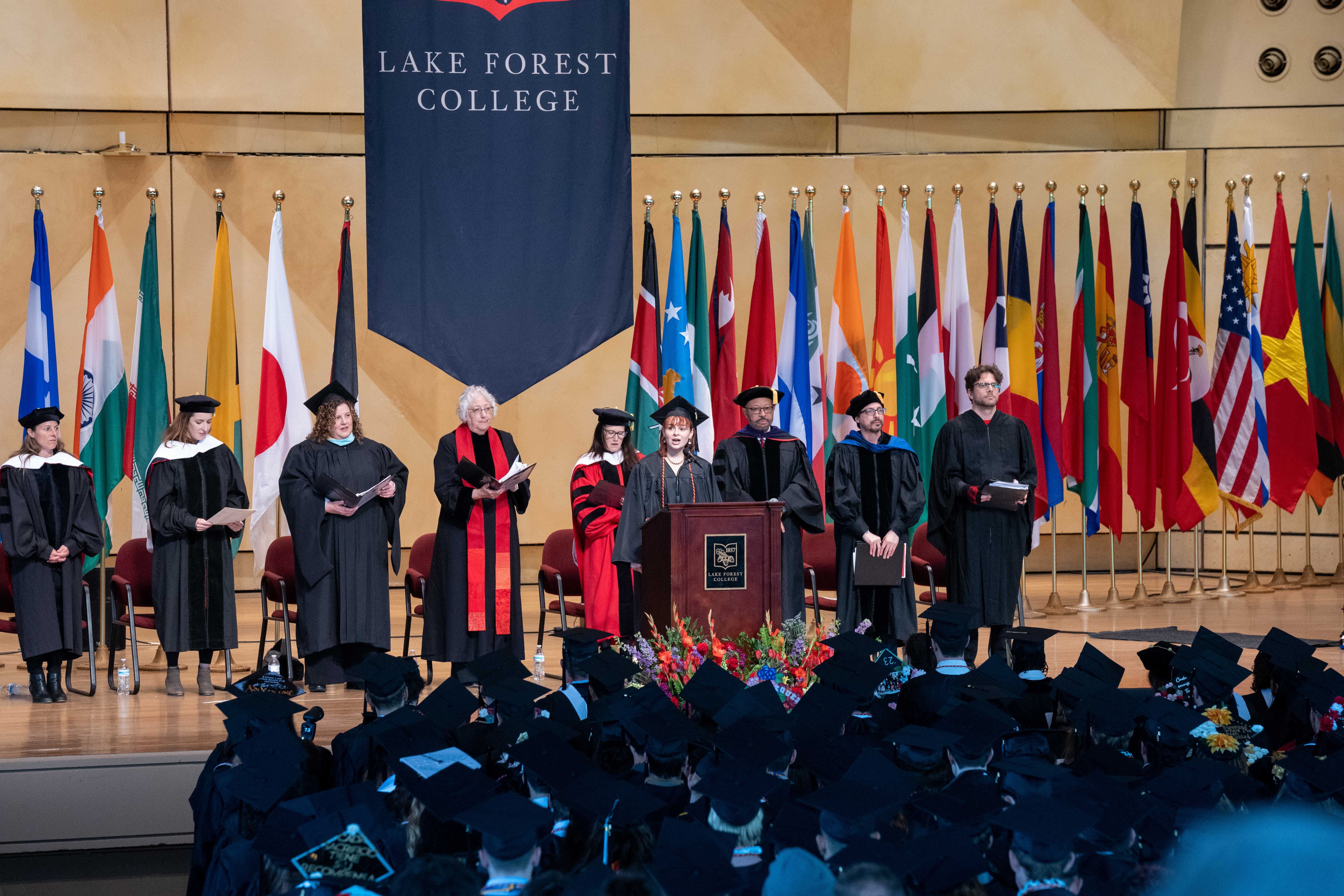 grad sings on stage at commencement