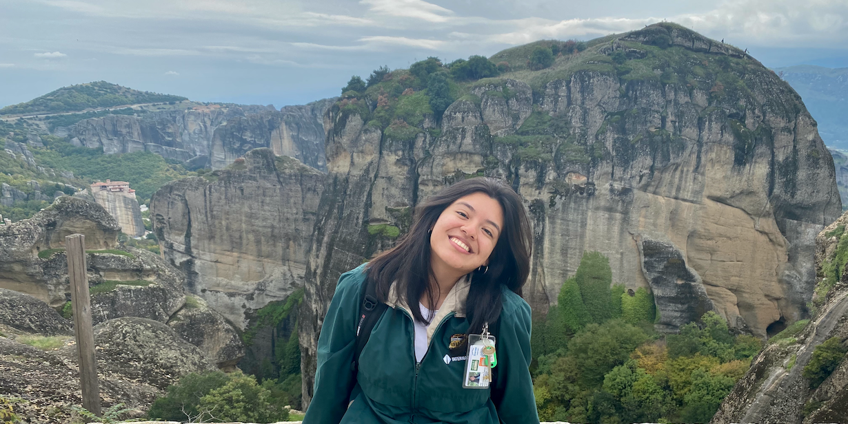 a student in front of a mountain range in greece