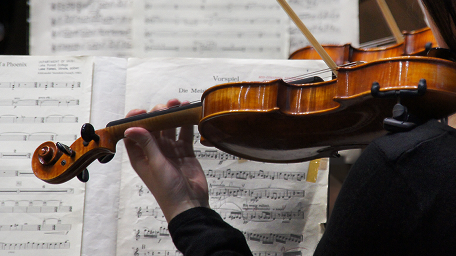 a violin with sheet music in the background