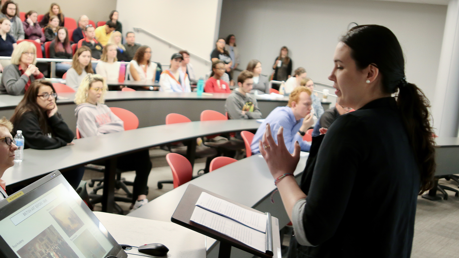 a student presenting to a group of students and faculty