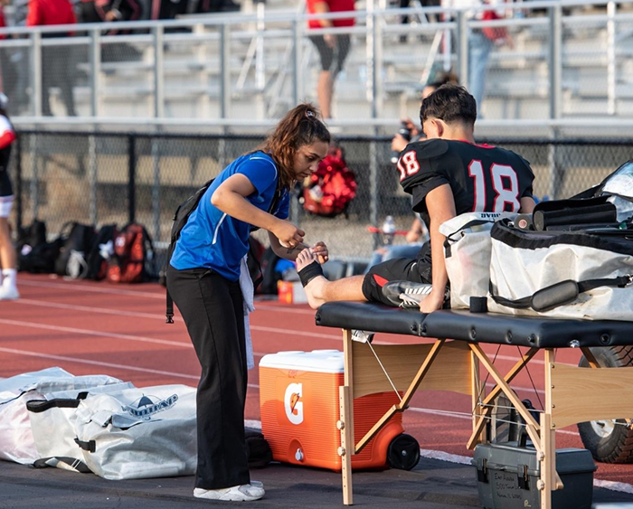 Athletic trainer tending to football player