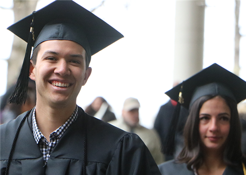 Male and female graduates in gowns and mortarboards