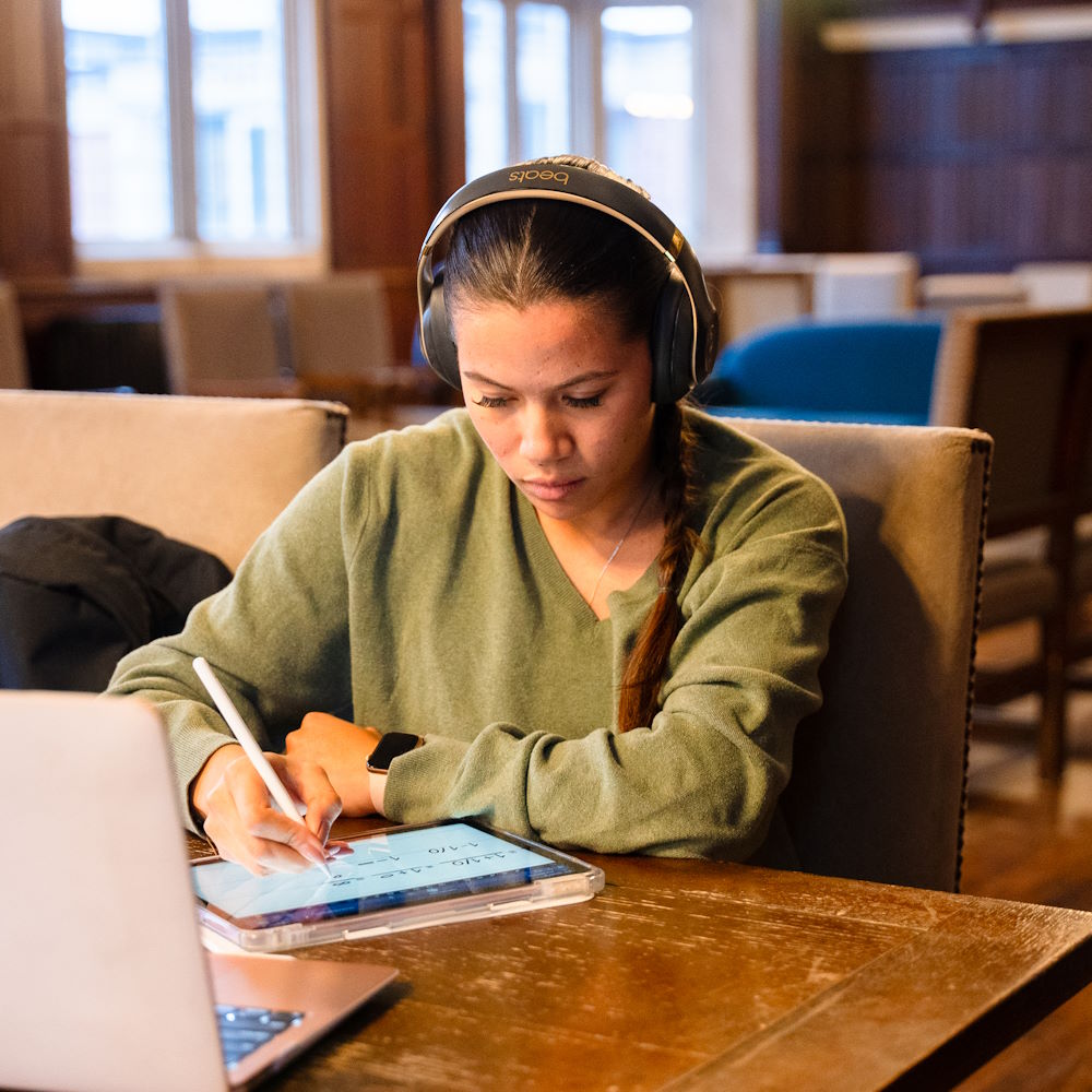 A student writing on a tablet