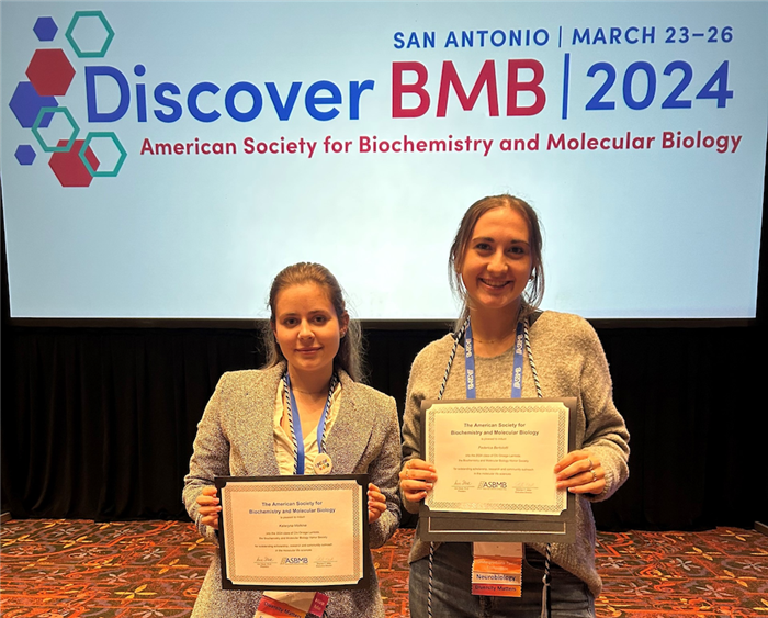 Student holding awards at conference