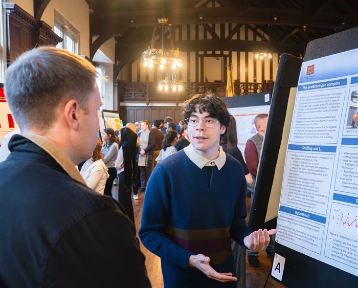 Student explaining research during symposium