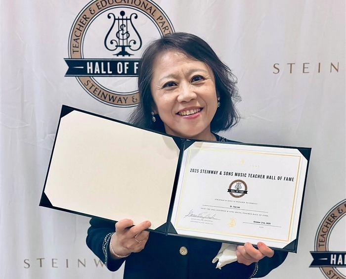 Soo Lee holding award