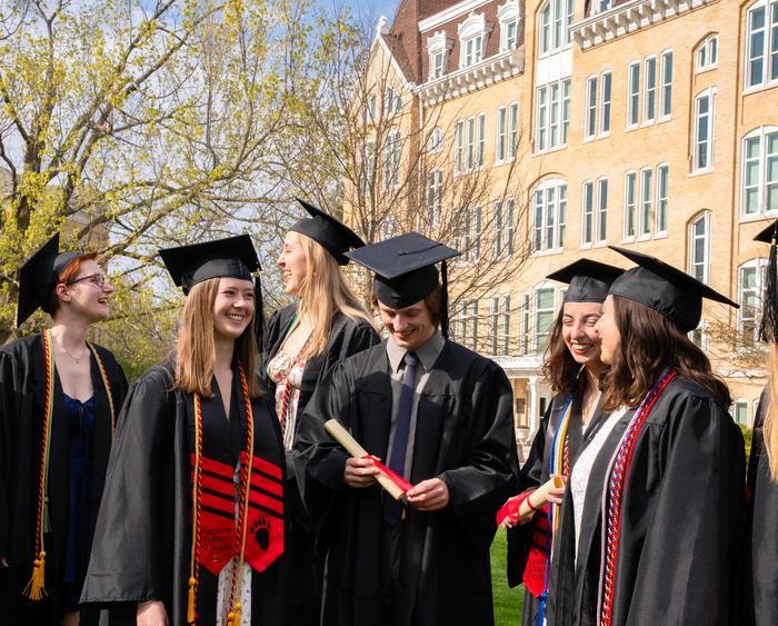students in caps and gowns smiling