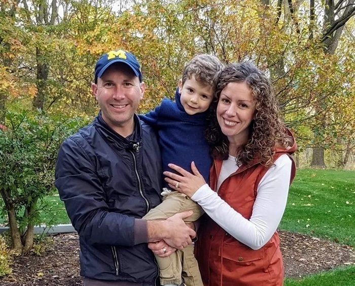 Portrait of parents holding young child in backyard