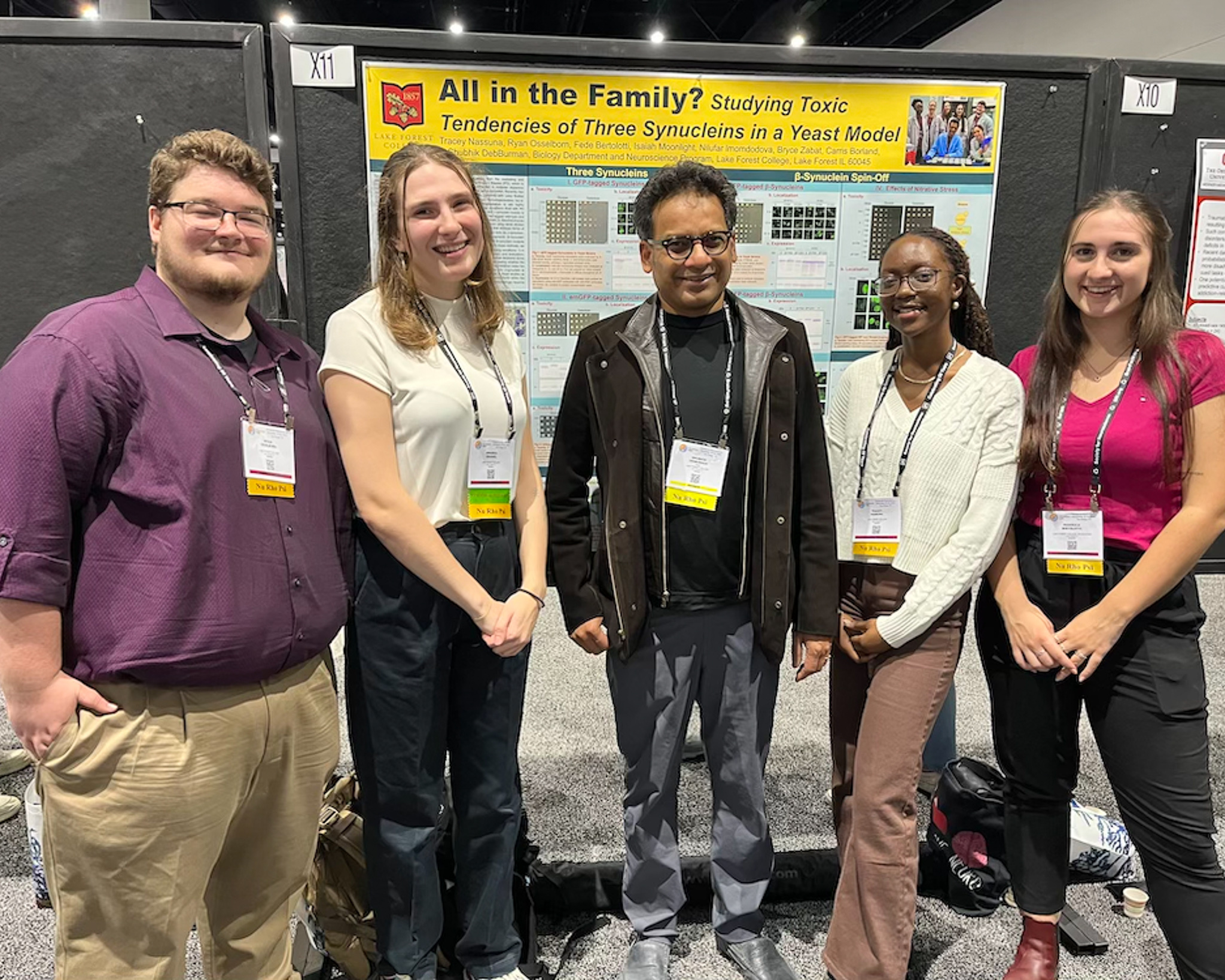 Students and debburman at the conference in front of poster