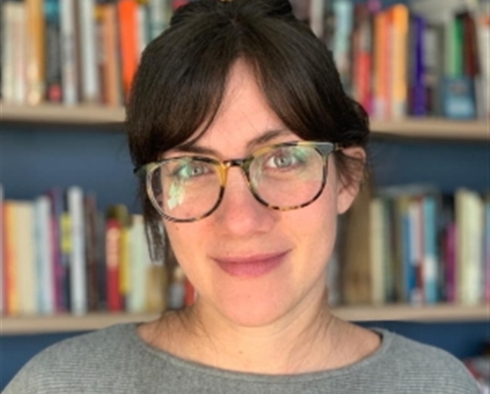 Headshot of Professor Denise Kripper in front of bookshelves