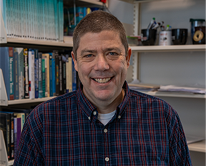 Robert Lemke in front of bookshelves