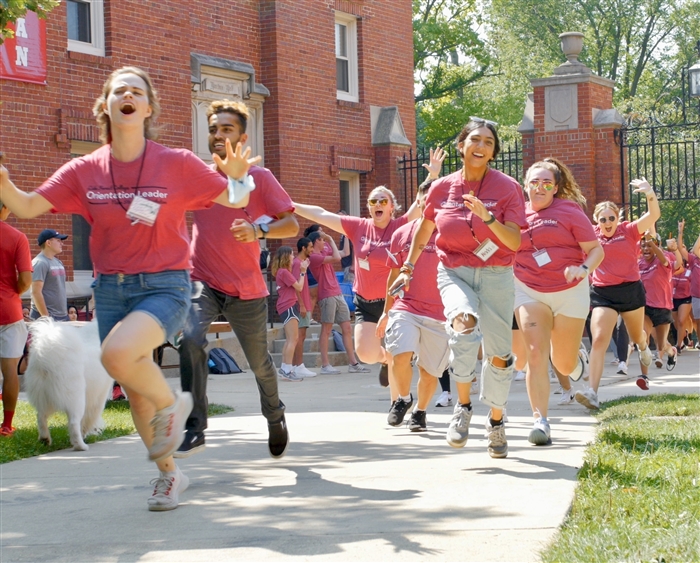 Student guides running through Middle Campus gates