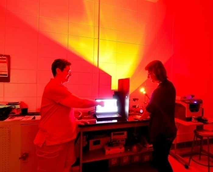 professor and student in red-lit lab