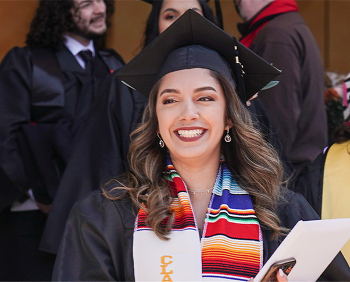 Graduate with cap and multi-colored stole