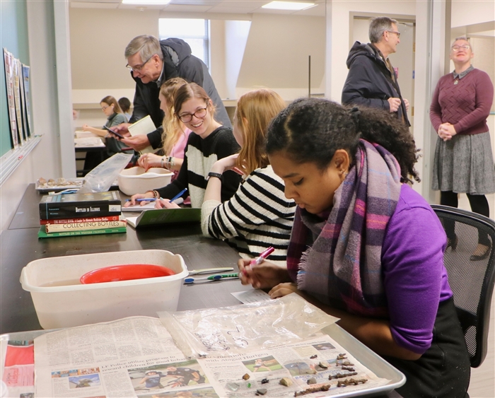 students cleaning artifacts in archaeology lab