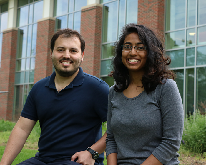 Professor and student sitting on low brick wall