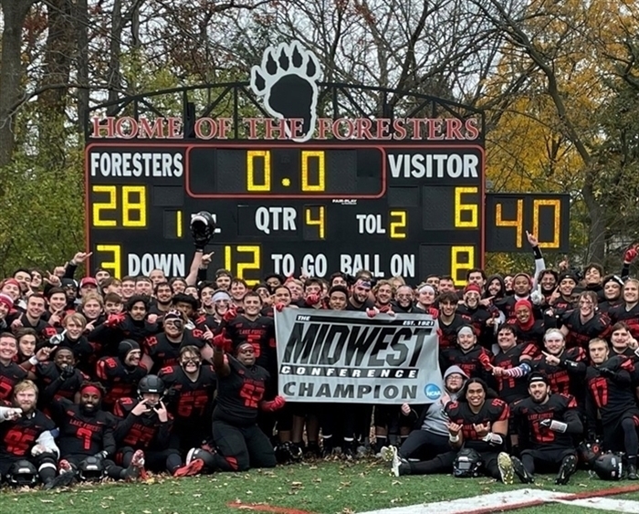 Football team on field in front of final season scoreboard