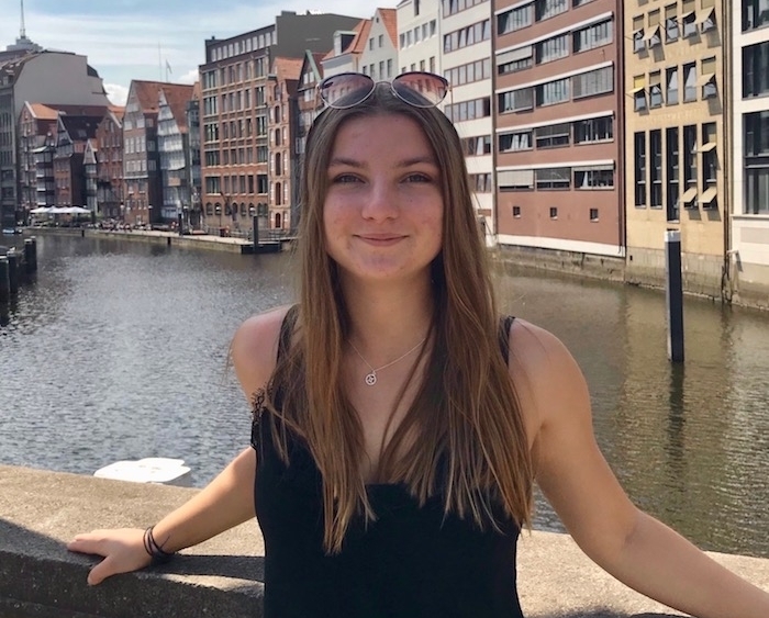 female in front of cityscape