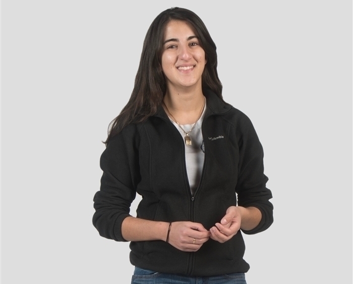 student posing in front of white background