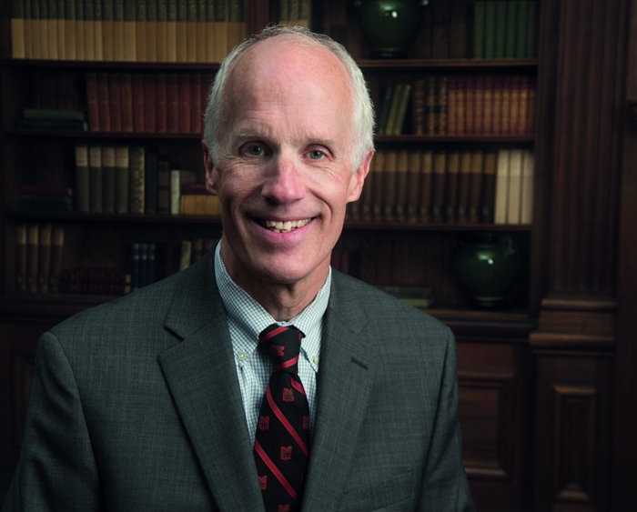 President Stephen Schutt in front of bookshelf