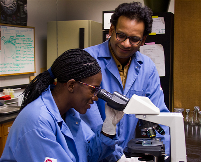 Professor with student at microscope