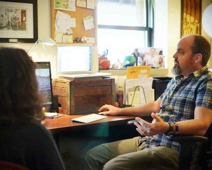 professor in his office talking with a student