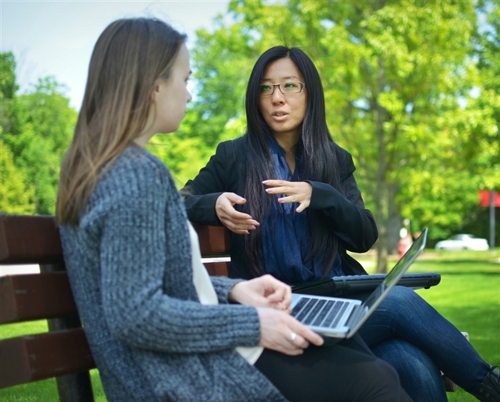 professor and student on bench outside talking