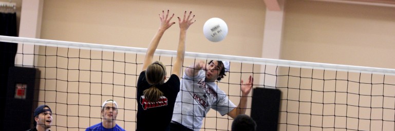 people playing volleyball in a gym